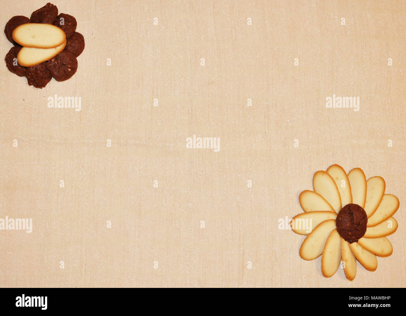Poco marrone e bianco cookies negli angoli su uno sfondo beige, vista dall'alto, laici piatta Foto Stock
