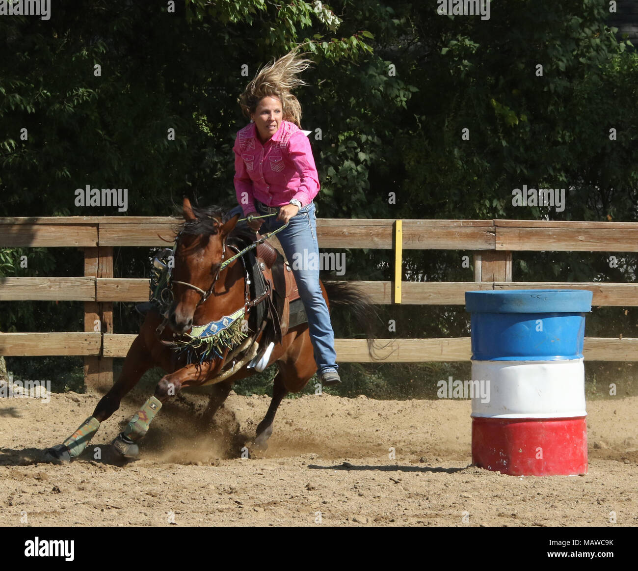 Barrel racing. La donna a cavallo con piedi fuori delle staffe e prendere l'aria al di sopra della sella. Canfield fiera. Mahoning County Fair. Canfield, Youngstow Foto Stock