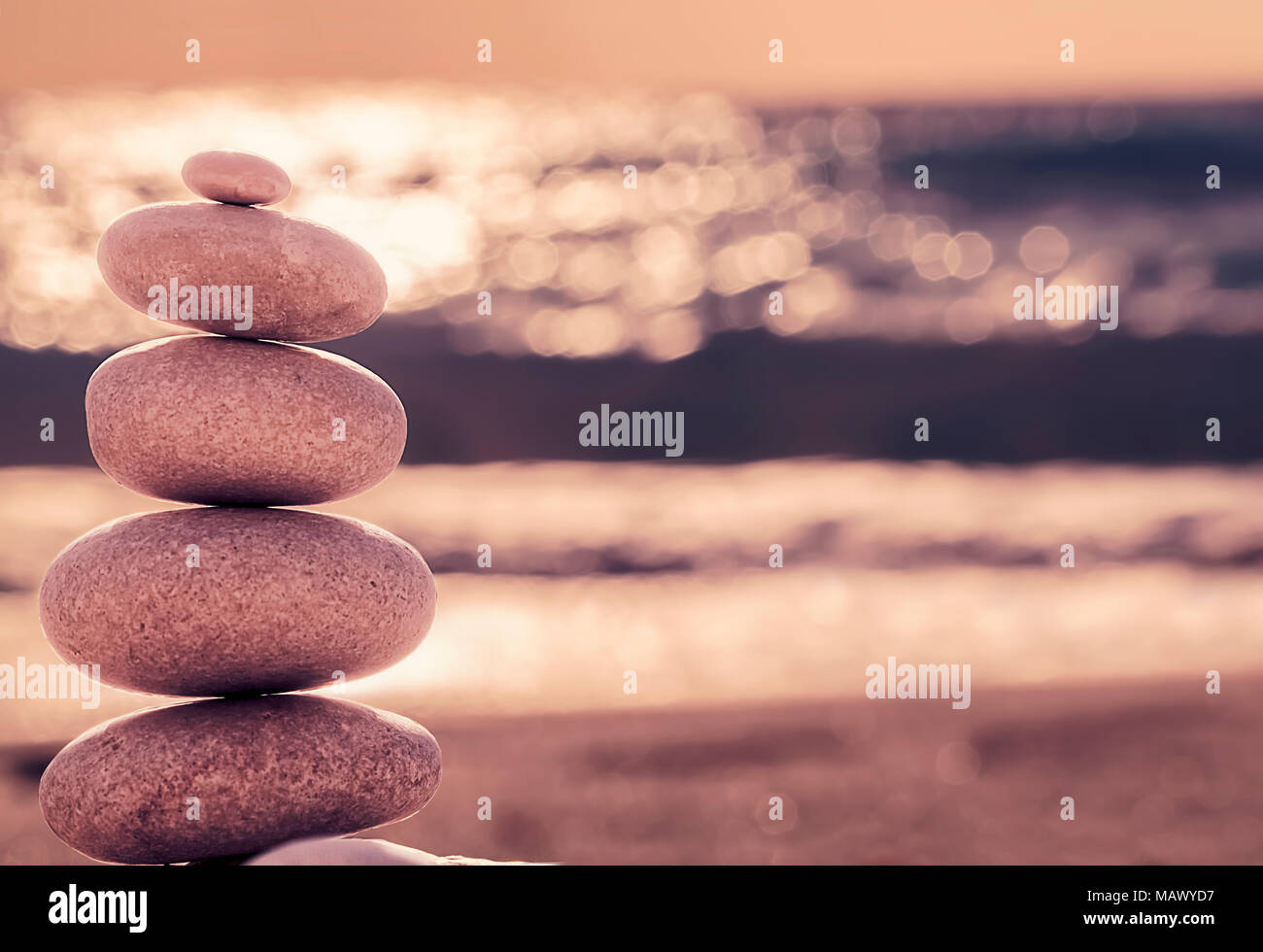 Vintage stile hipster meditazione Zen, sfondo equilibrato stack di pietre sulla spiaggia del mare Foto Stock