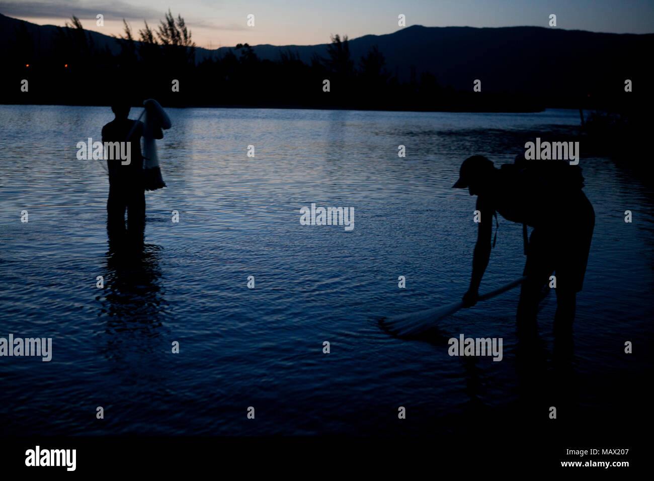 Un pescatore si diffonde rete da pesca per la cattura di gamberi di fiume in un tramonto locale: Garopaba/SC Autor: E Foto Stock