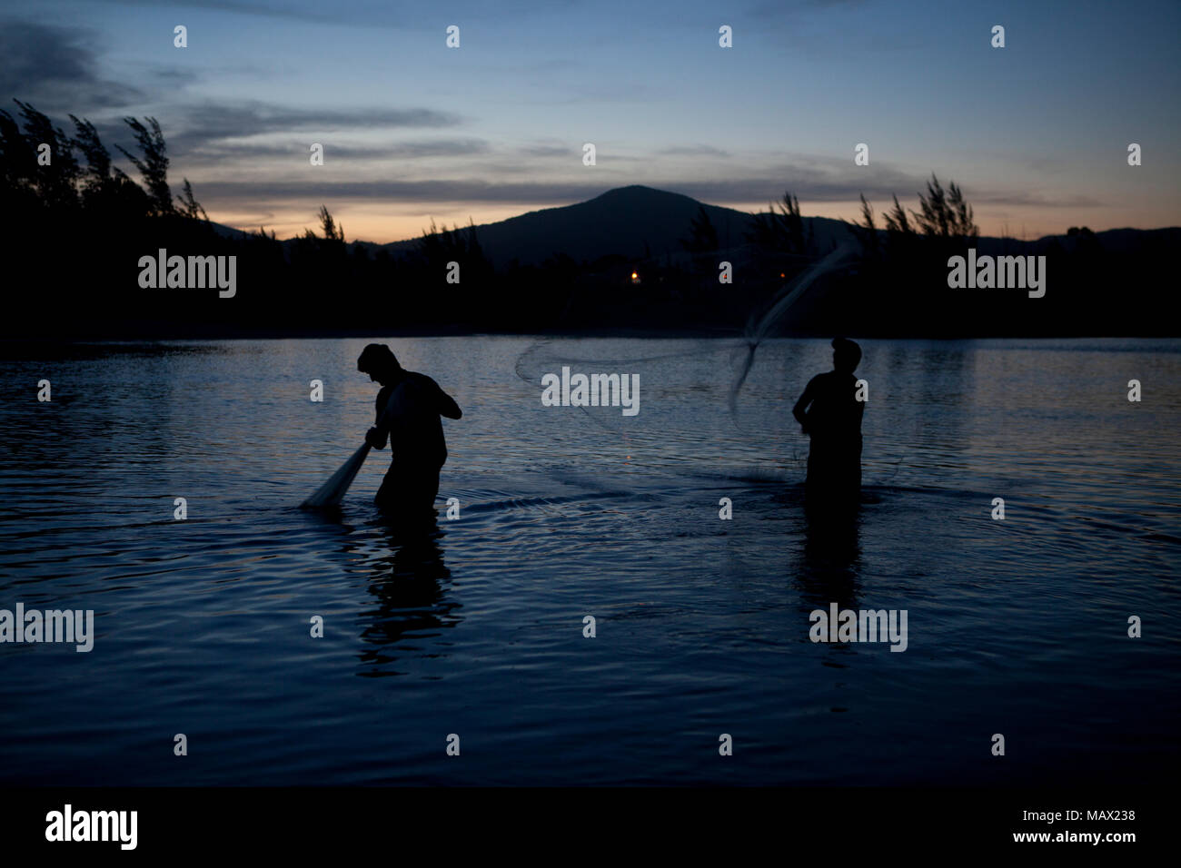 Un pescatore si diffonde rete da pesca per la cattura di gamberi di fiume in un tramonto locale: Garopaba/SC Autor: E Foto Stock