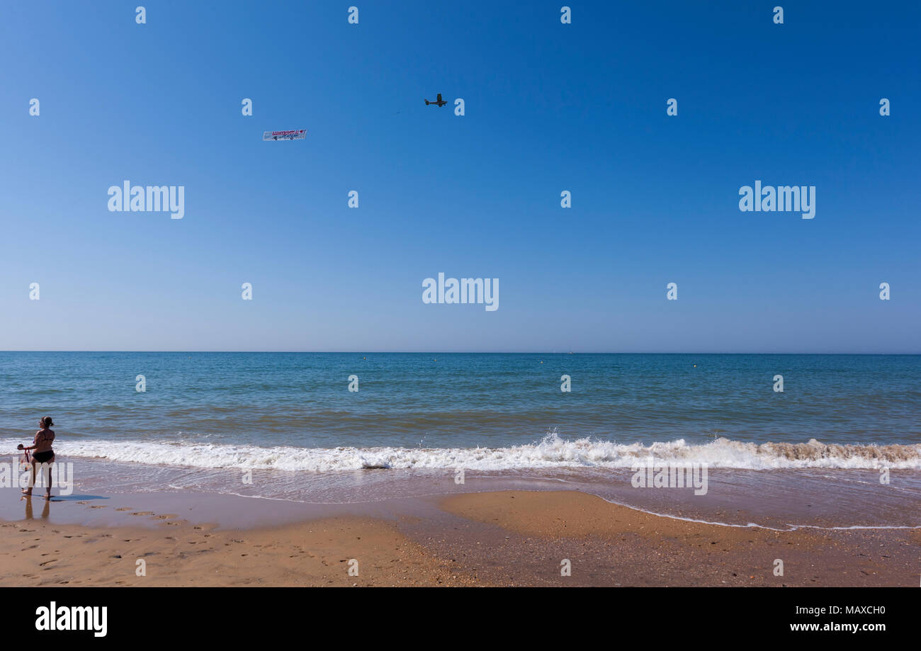 Bagnante rispettando un piano pubblicitario battenti in Parador Mazagon spiaggia, provincia di Huelva, Andalusia, Spagna Foto Stock