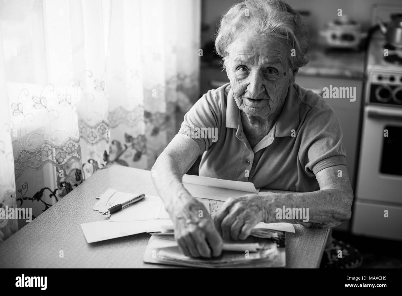 Donna anziana pensionata con fatture da pagare le utility. Foto Stock