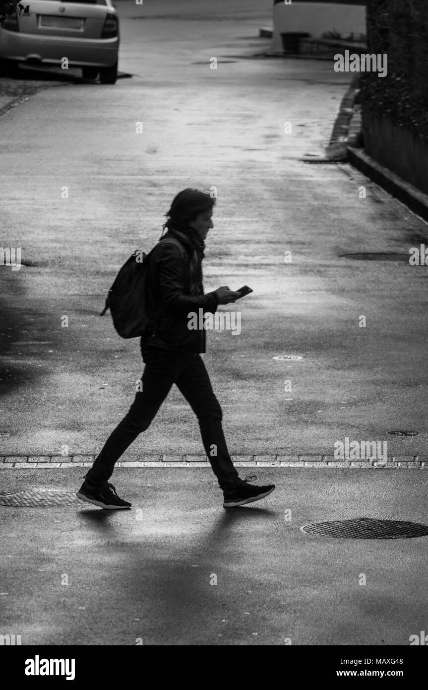 Uomo che cammina in bianco & nero Foto Stock