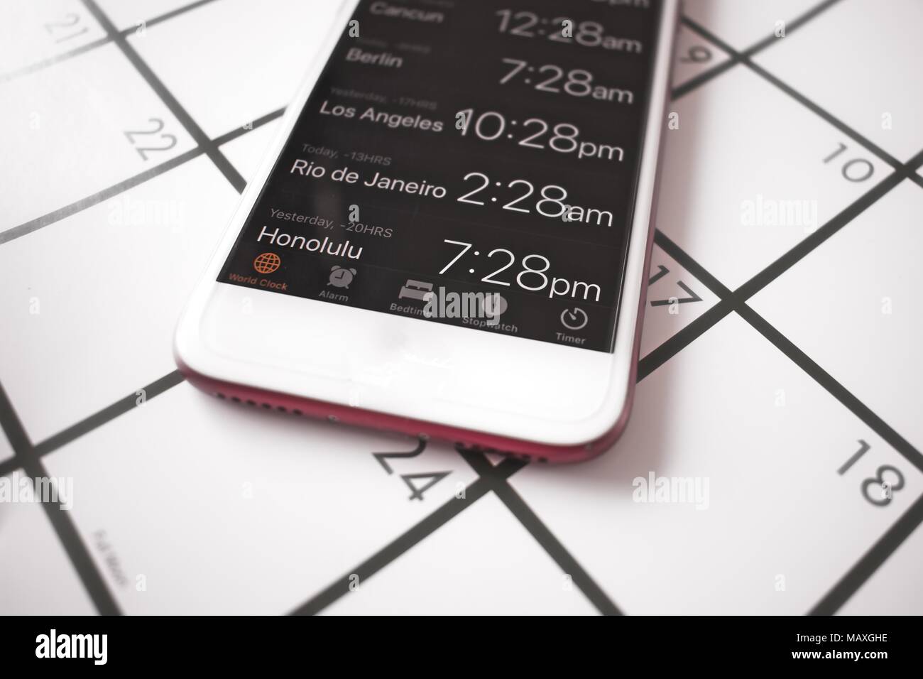 Un calendario e orologio mondiale sul telefono cellulare sono utilizzati per viaggi in zone con fusi orari diversi Foto Stock