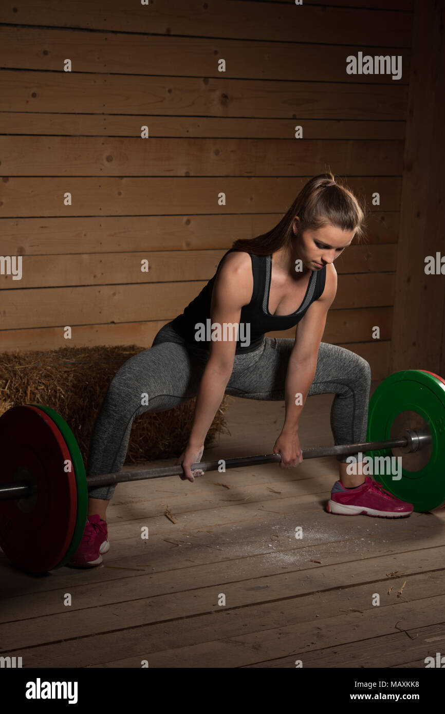 Attivo atleta donna che lavora fuori con barbell - powerlifting Foto Stock