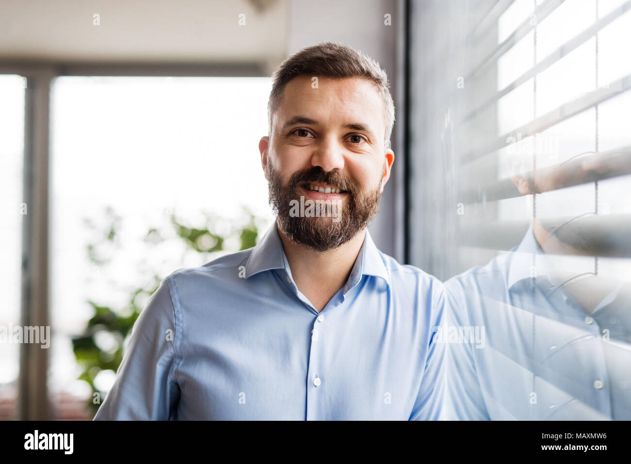 Un uomo dalla finestra a casa. Foto Stock