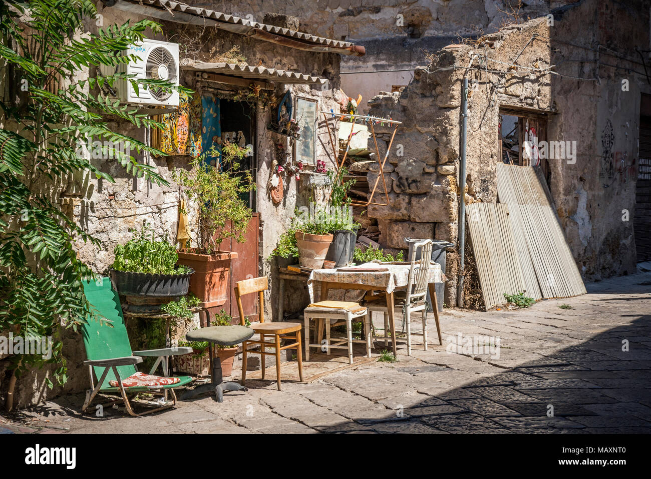 I tavoli e le sedie al di fuori di un osteria (posto che serve cucina semplice e vino) nelle stradine della Sicilia. Foto Stock