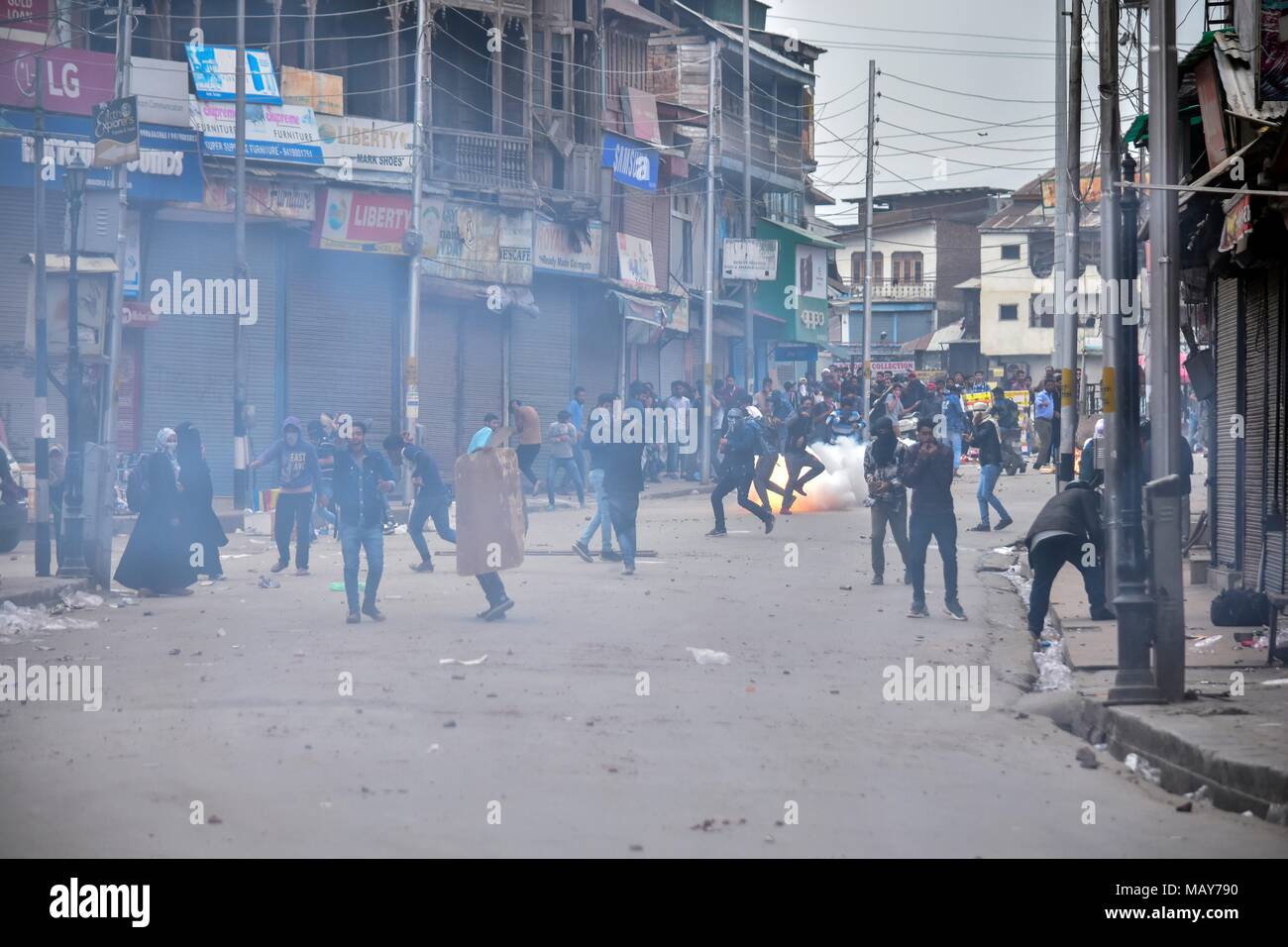 5 aprile 2018 - Srinagar, J&K, India - un gas lacrimogeni shell sparati da poliziotti indiano esplode vicino agli studenti del Kashmir durante scontri a Srinagar, Indiano Kashmir amministrato. Violenti scontri scoppiati tra le forze governative e gli studenti in Srinagar il giovedì come la valle ha continuato a rimanere tesa oltre l uccisione di 17 persone di cui 13 militanti e 4 civili in incontri separati nel sud del Kashmir. Polizia strappo utilizzati gusci di fumo per scacciare i manifestanti. La violenza che ha sconvolto la valle del Kashmir il giorno in cui le autorità hanno abolito le restrizioni dopo quattro giorni di arresto. (Credito immagine: Foto Stock