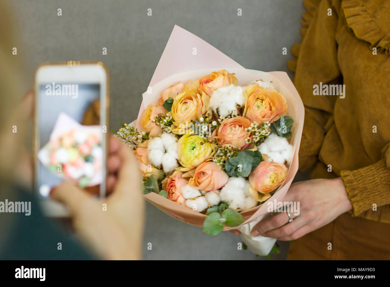 Ragazza tira sullo smartphone bellissimo bouquet rustico in amico le mani Foto Stock