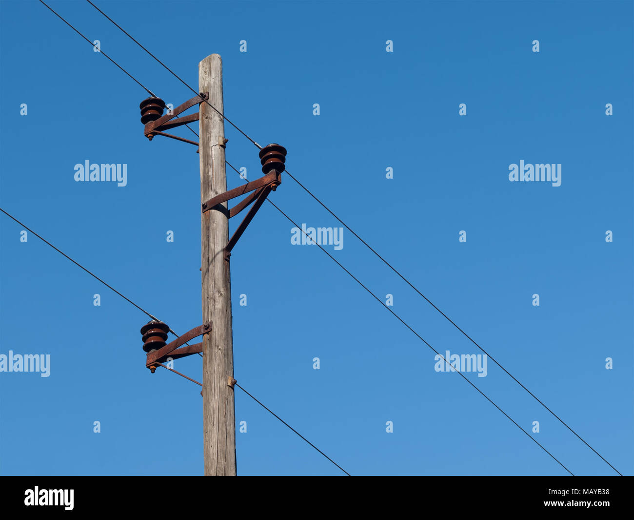 In legno antico polo elettrico con fili e cielo blu Foto Stock