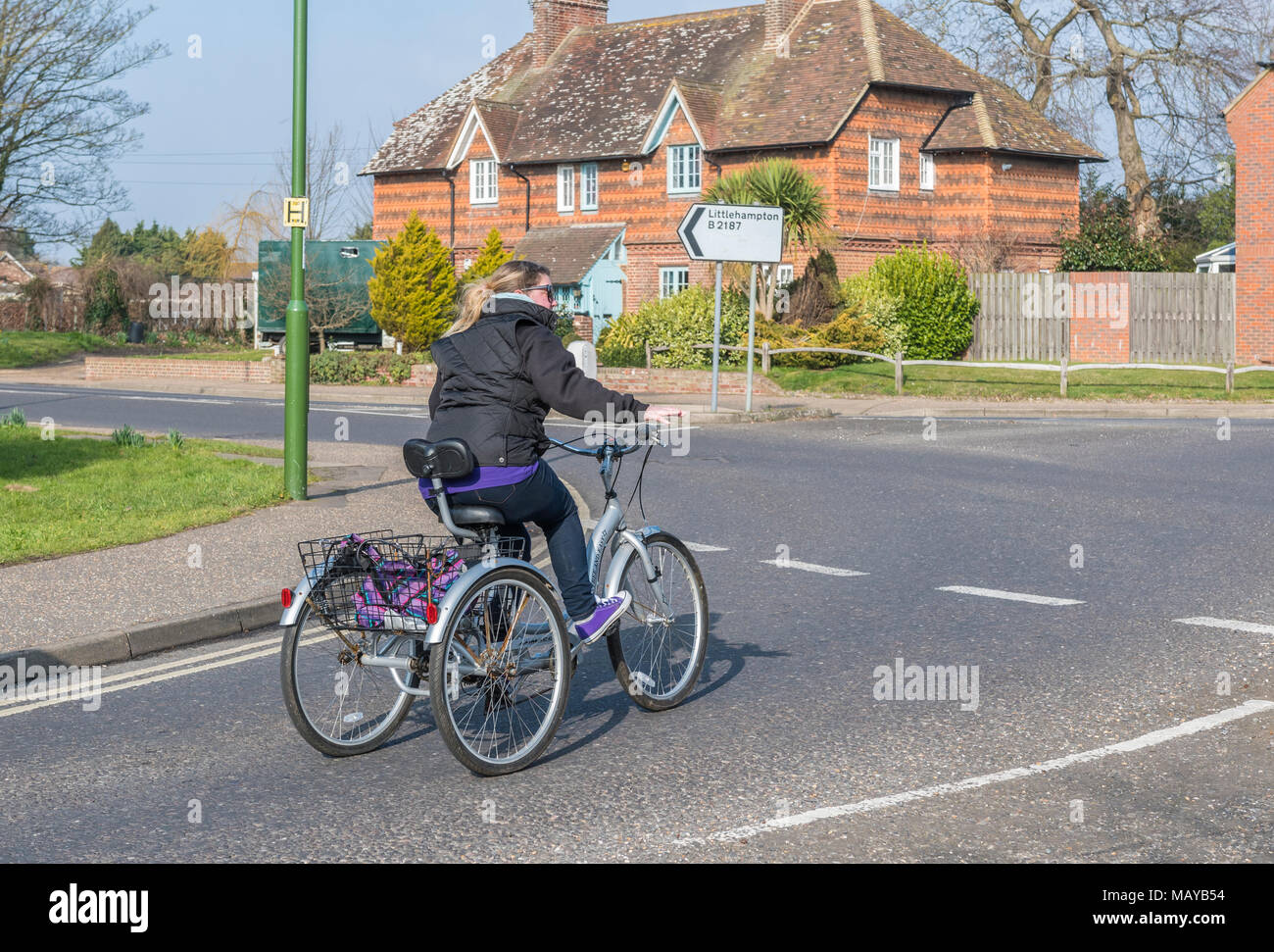La donna a cavallo di un triciclo a pedali bike con 3 ruote, in Inghilterra, Regno Unito. Foto Stock