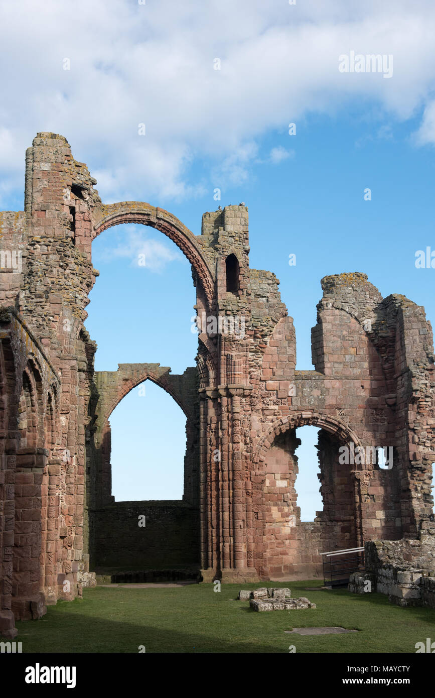 Rovine del Priorato di Lindisfarne a Holy Island, Northumberland, Inghilterra, sotto un cielo blu brillante. Sito storico del monastero cristiano Foto Stock