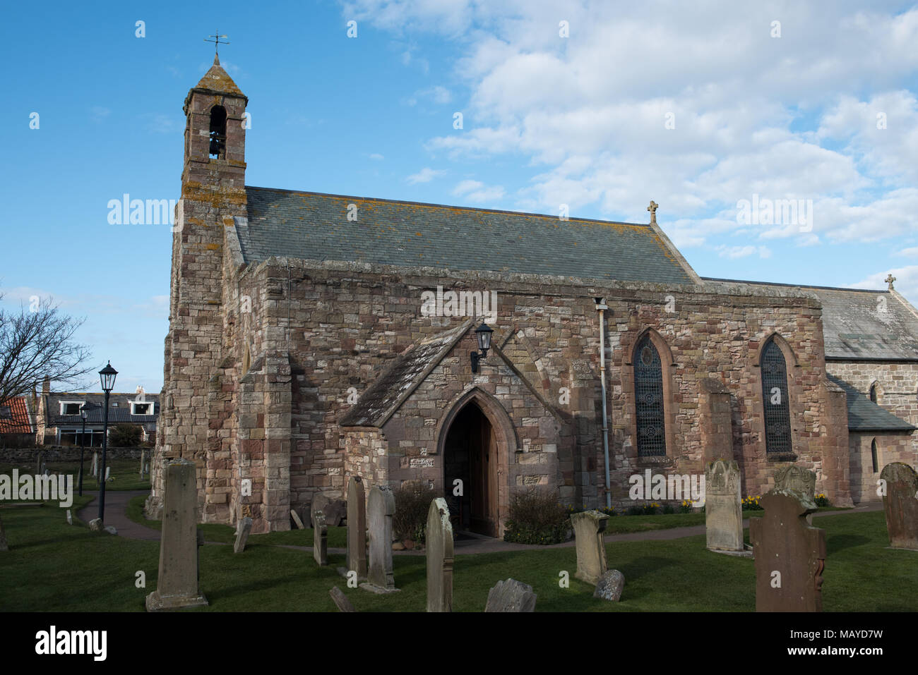 Chiesa di Santa Maria sull'Isola Santa (Lindisfarne), con lapidi e cielo blu, storico sito cristiano nel Northumberland, in Inghilterra Foto Stock