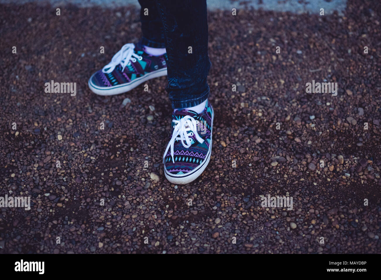 Donna sneakers con disegno tribale sulla ghiaia Foto Stock