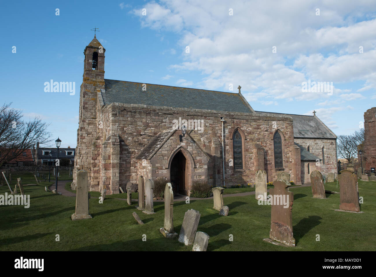 Chiesa di Santa Maria sull'Isola Santa (Lindisfarne), con lapidi e cielo blu, storico sito cristiano nel Northumberland, in Inghilterra Foto Stock