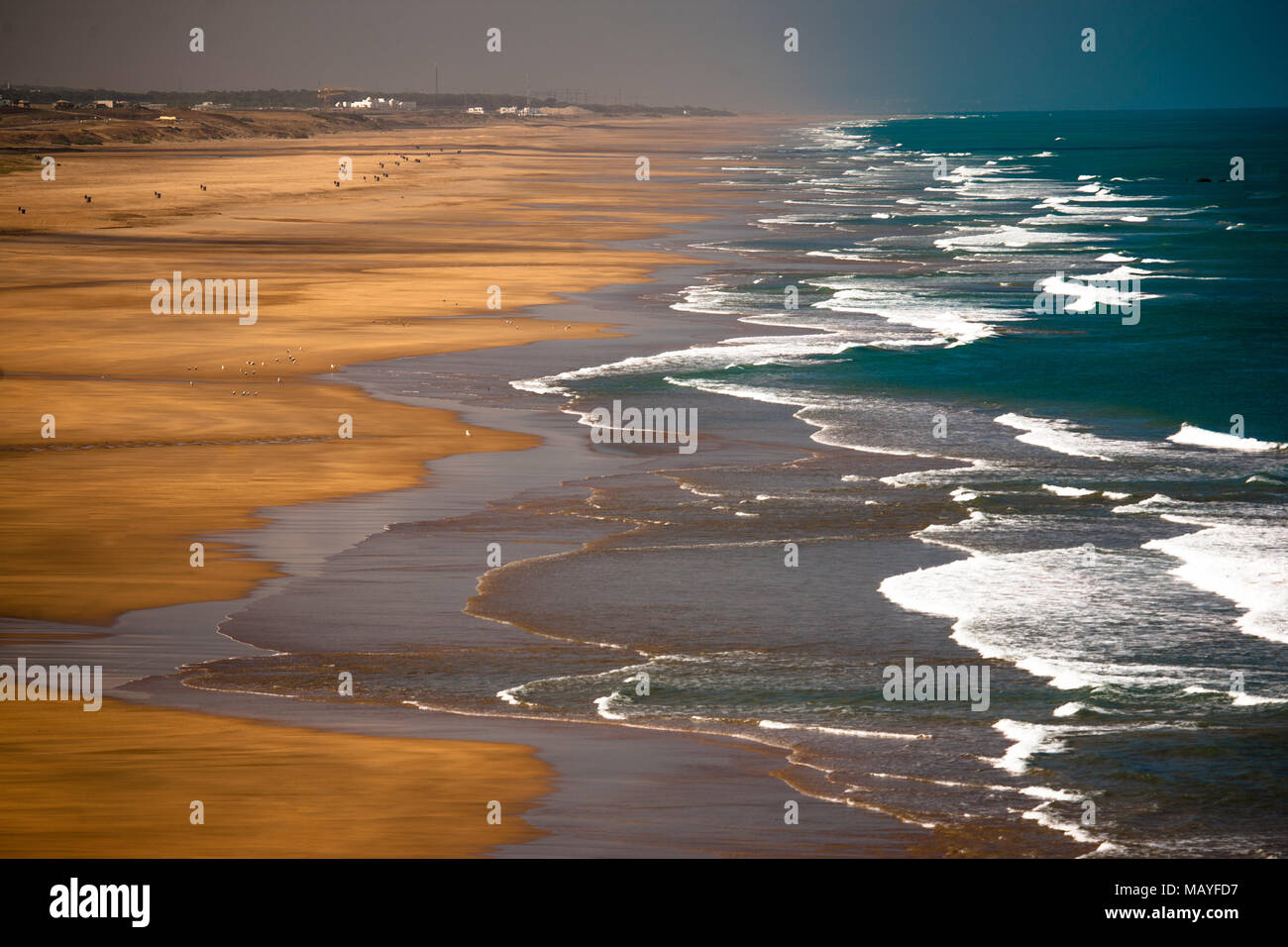 Onde infrangersi lungo una spiaggia deserta in Tunisia. Foto Stock
