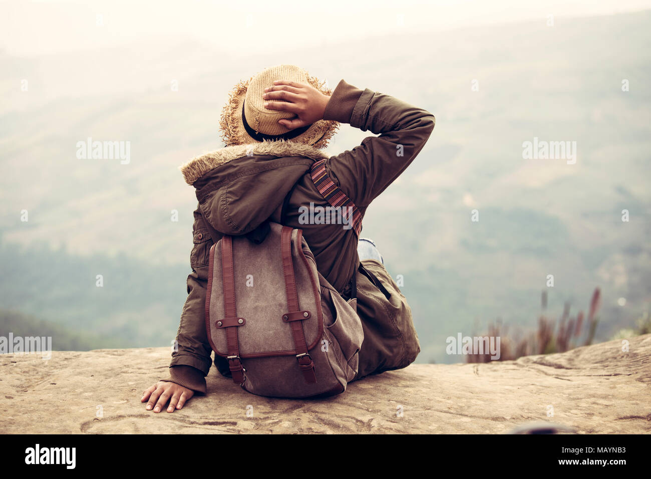 Hipster donne traveler mano testa con seduta backpacker guardare a vista sulla montagna di viaggio. Foto Stock