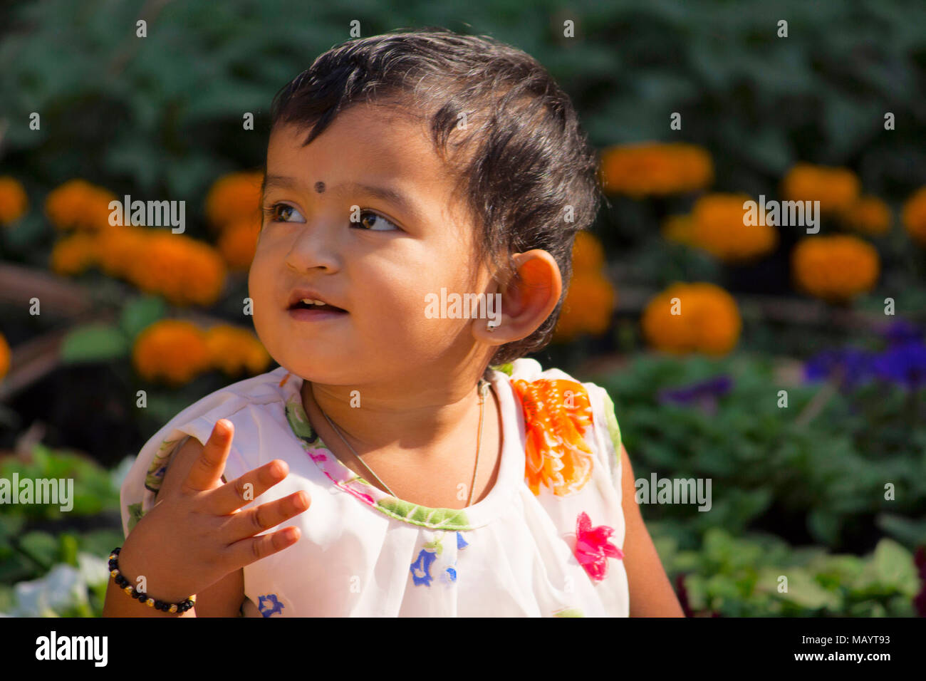 Bambina Giochi nel giardino guardando la telecamera, Imperatrice giardino a Pune Foto Stock