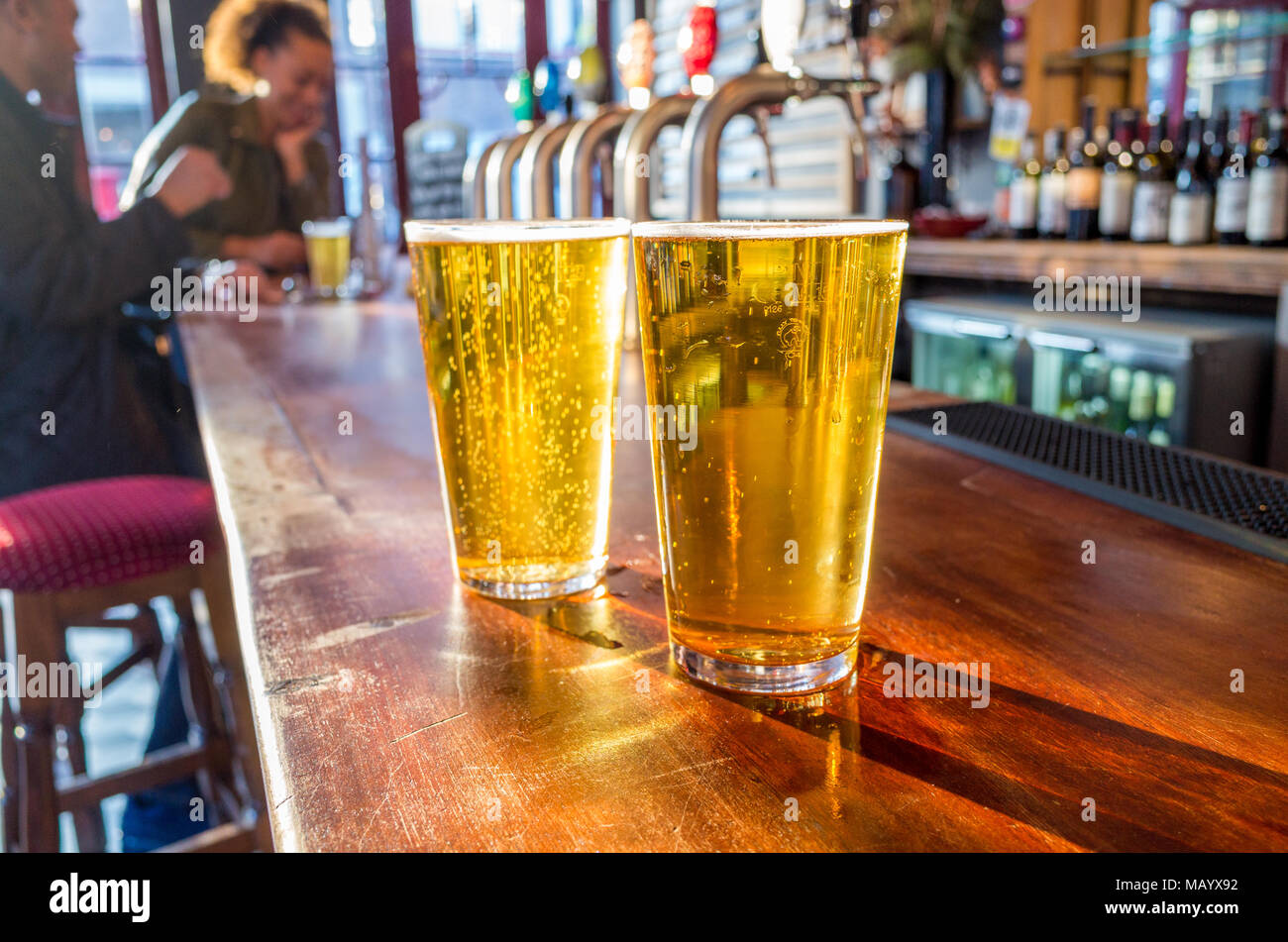 In prossimità dei due pinte di birra lager sulla barra di un pub, UK, Londra Foto Stock