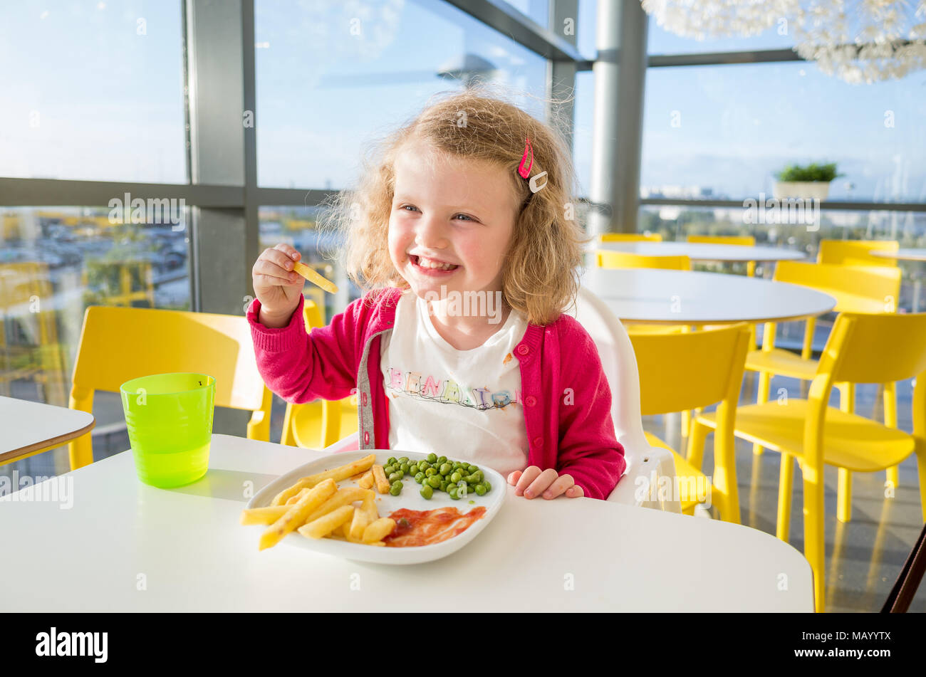 Piccolo bambino mangiare pasto dal menu per bambini nel ristorante di Ikea, Edmonton, London, Regno Unito Foto Stock