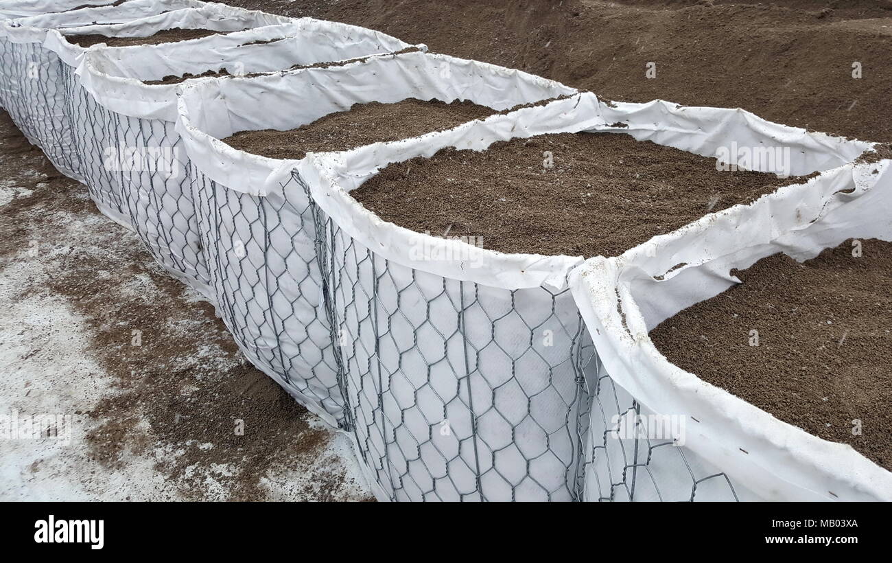 Nuove barriere sandbox di protezione dalle inondazioni appena impostato e riempito con sabbia in attesa alluvione che sopraggiungono Foto Stock