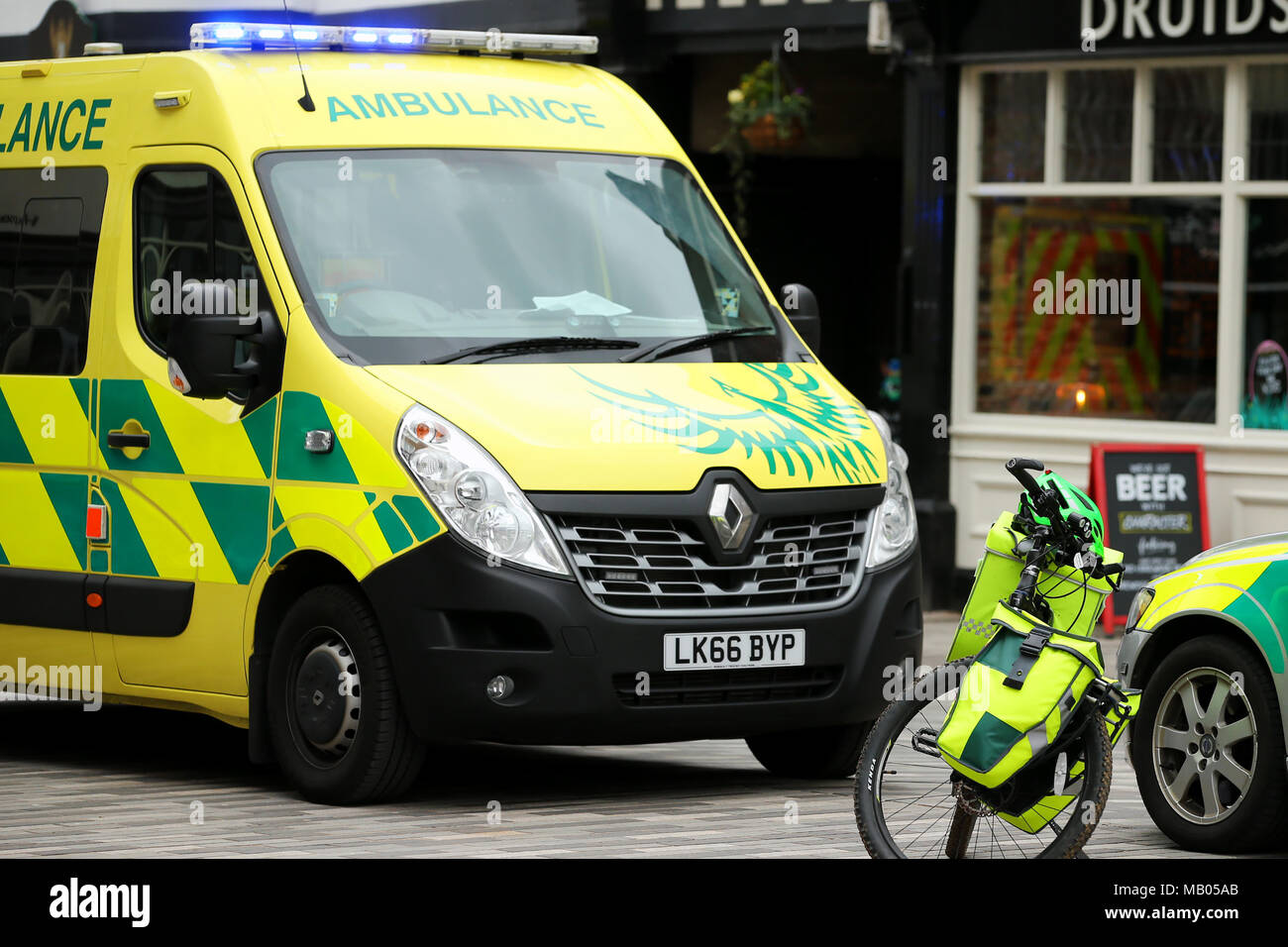 Medico di tre veicoli parcheggiati insieme, un ambulanza van, una bicicletta e un auto medica frequentare un emergenza in Kingston. Foto Stock