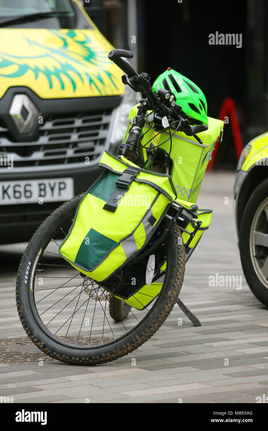 Medico di tre veicoli parcheggiati insieme, un ambulanza van, una bicicletta e un auto medica frequentare un emergenza in Kingston. Foto Stock
