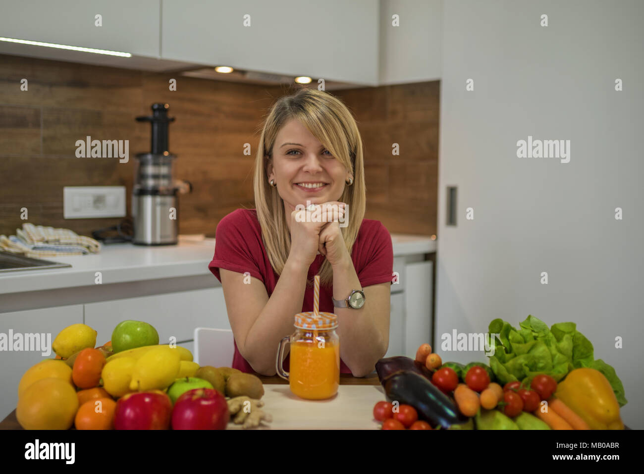 Giovane donna frullato potabile in cucina. Close up ritratto di giovane donna in cucina. Cibo sano - insalata di verdure. La dieta. Concetto di dieta. Foto Stock