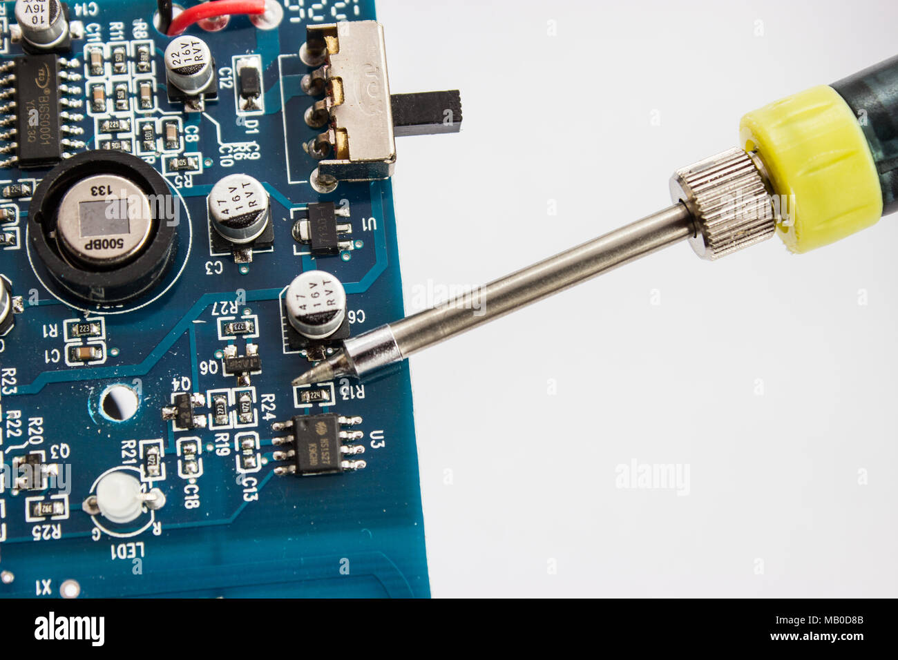La saldatura di stagno di componentzs elettroniche sulla scheda a circuito stampato. Foto Stock