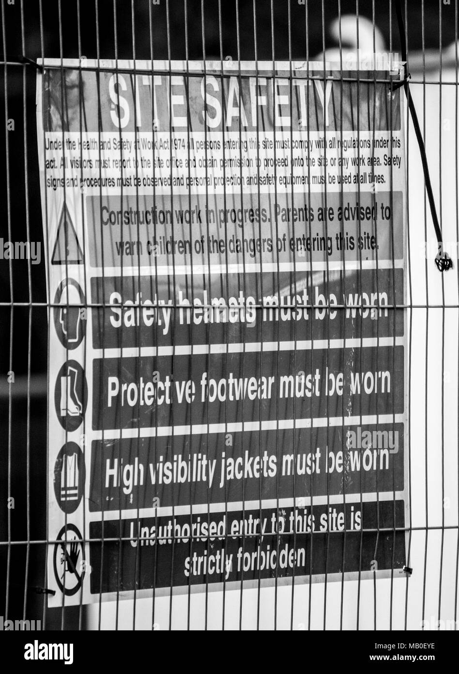 Heath e segnaletica di sicurezza visualizzata su un Heras recinzione in corrispondenza di un sito in costruzione Foto Stock