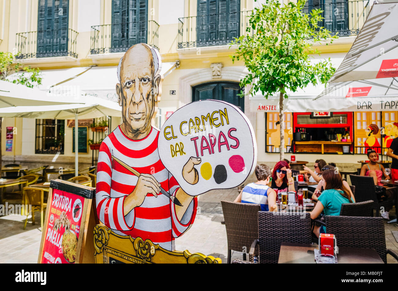 Malaga, Andalusia, Spagna : i giovani donne a un esterno tapas bar in Plaza del Carmen square con Pablo Picasso sign in primo piano. Foto Stock