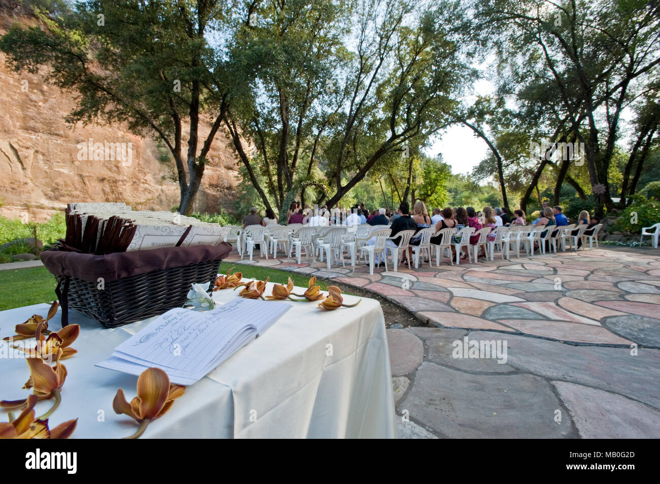 Un matrimonio all'aperto sotto ombrosi alberi di quercia nella parte anteriore di un fiume in corrispondenza di una sede in California, con un guest book tabella in primo piano Foto Stock