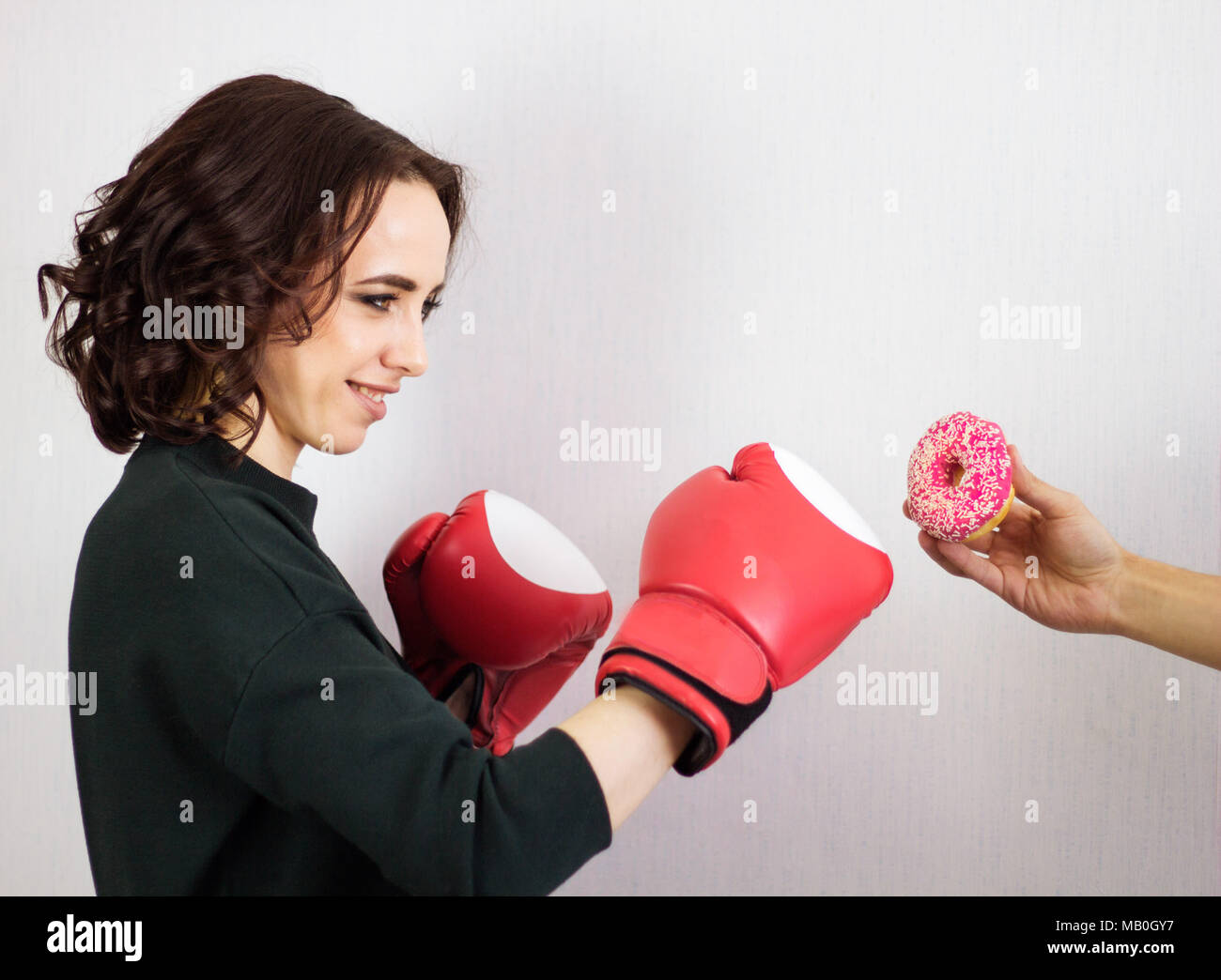 Donna boxe a ciambella in mano maschio, il concetto di forza di volontà,la  dieta Foto stock - Alamy