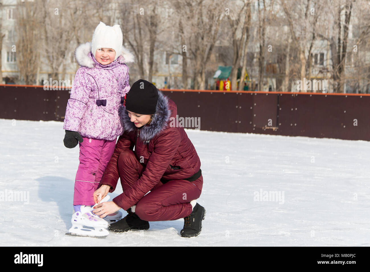 Una donna con una bambina su ghiaccio impara a pattinare d'inverno. Foto Stock