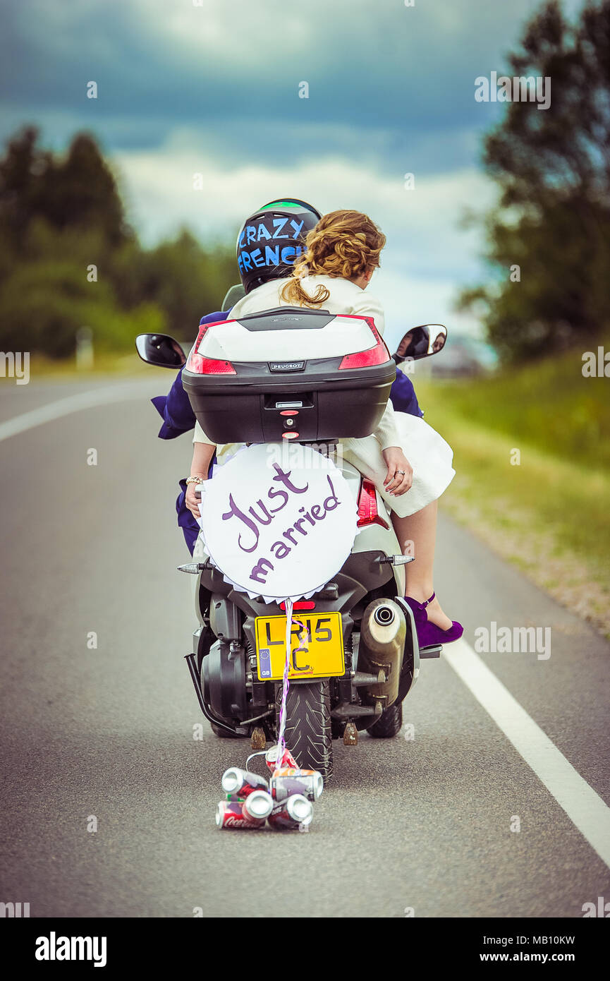 Appena sposata con segno e lattine su uno scooter Foto Stock