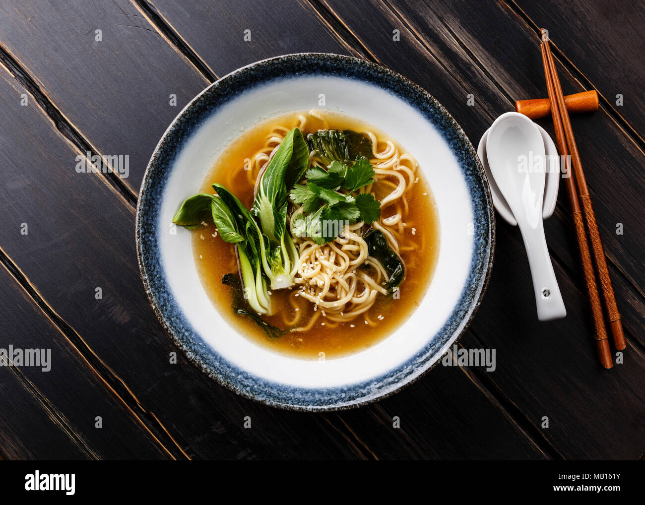 Ramen asian noodle in brodo con pak choi cavolo in ciotola di legno scuro dello sfondo Foto Stock