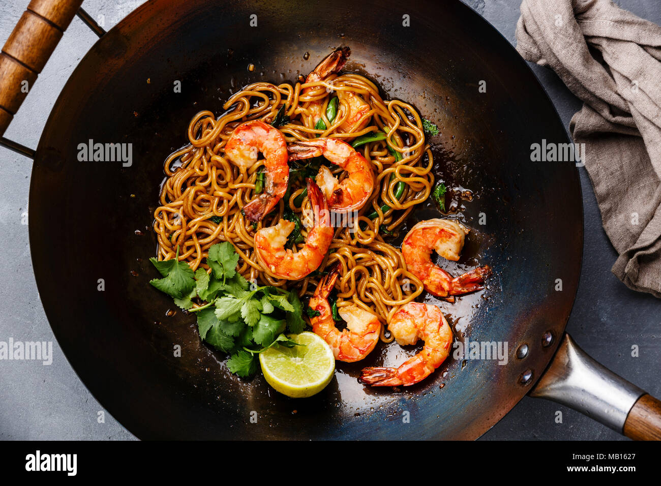Ramen friggere gli spaghetti con i gamberi nel wok padella in calcestruzzo  di colore grigio sullo sfondo di close-up Foto stock - Alamy