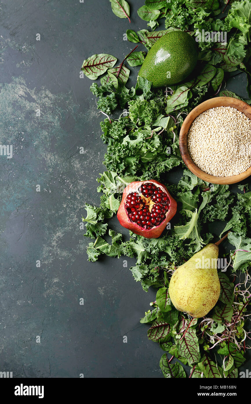 Insalata verde e frutta mix per insalata di cavolo riccio, giovani foglie di bietola, germogli, pera, avocado, melograno, ciotola di materie non cotti quinoa oltre il testo scuro Foto Stock