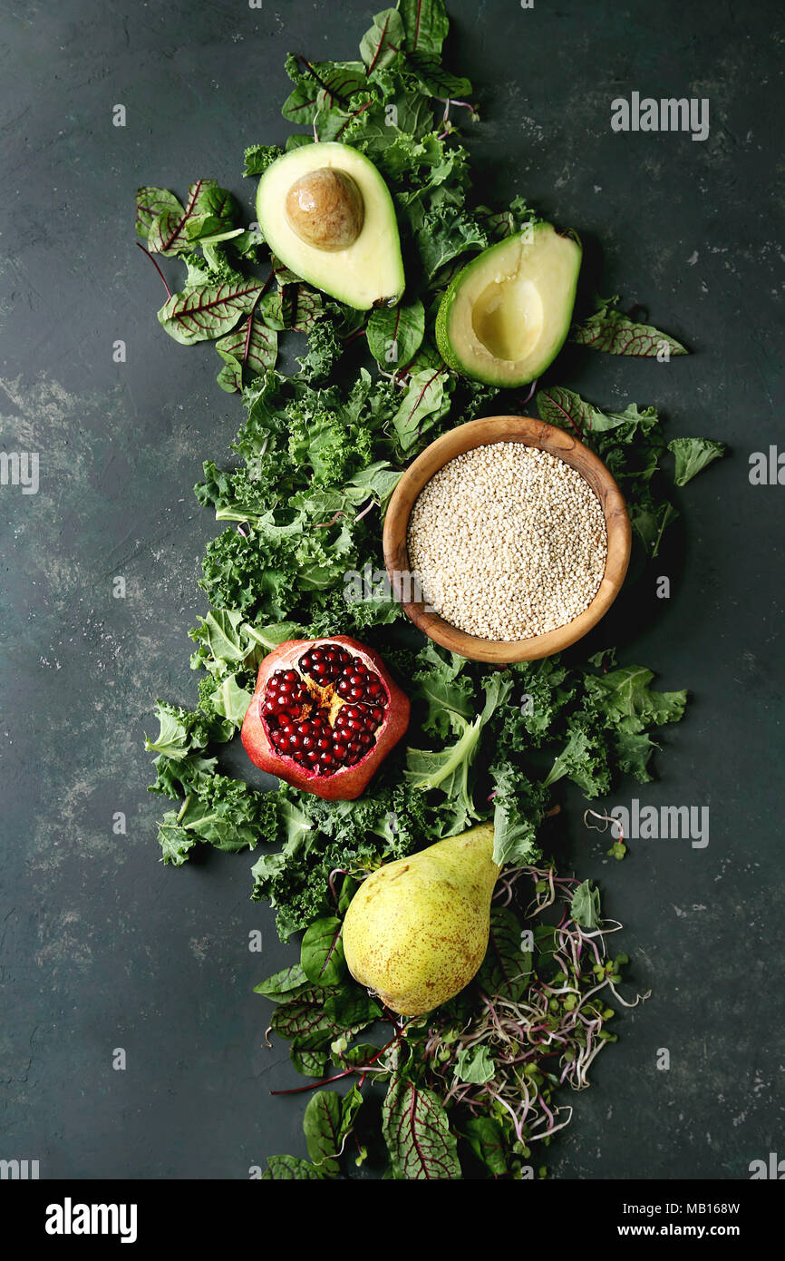 Insalata verde e frutta mix per insalata di cavolo riccio, giovani foglie di bietola, germogli, pera, avocado, melograno, ciotola di materie non cotti quinoa oltre il testo scuro Foto Stock