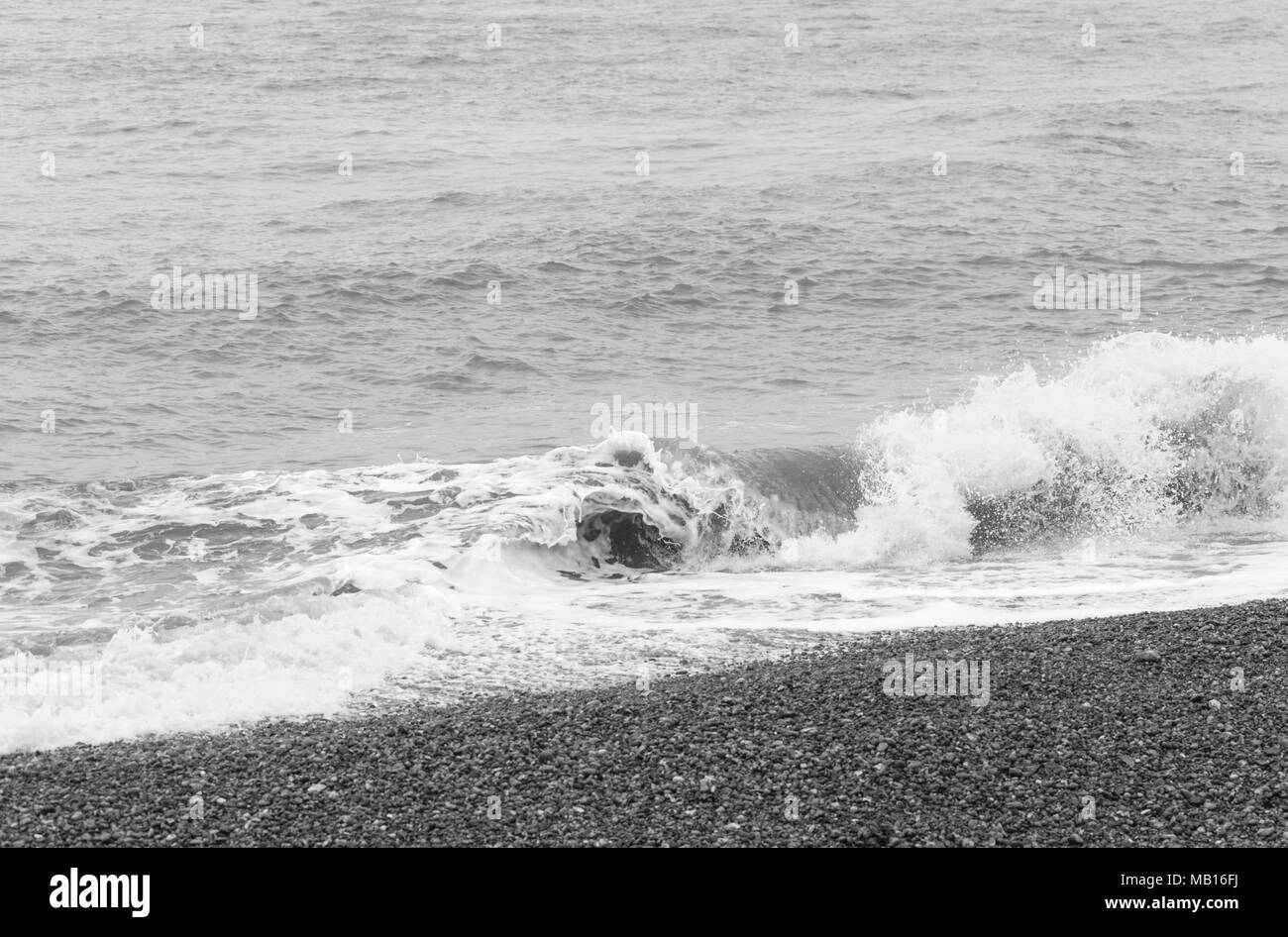 Rottura di onde sulla spiaggia di ciottoli di Eastbourne Foto Stock