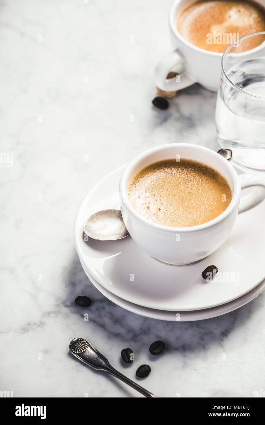 Composizione del caffè su marmo bianco dello sfondo. Caffè espresso Caffè in tazze bianche Foto Stock