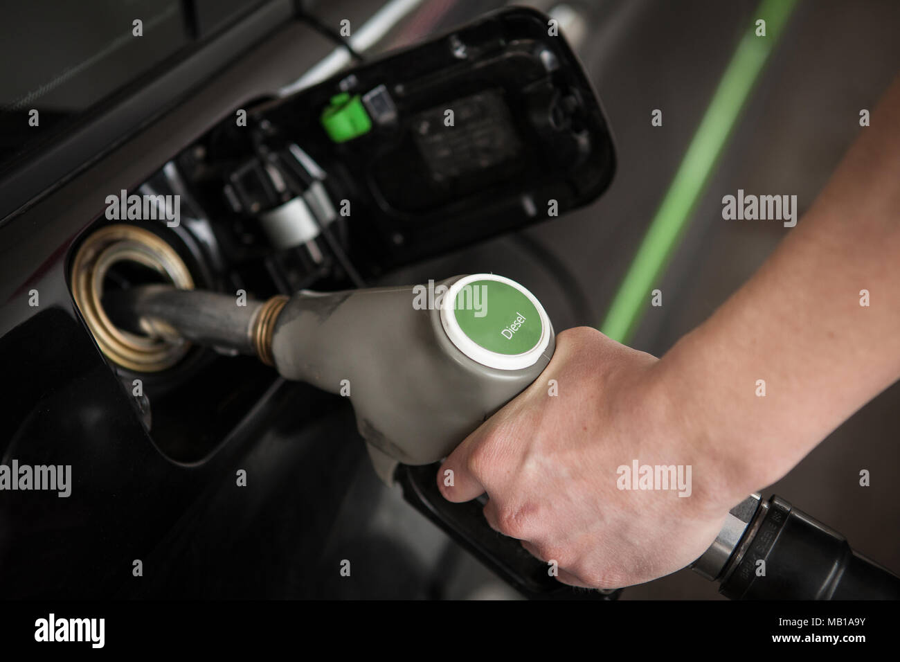 La mano di riempire il serbatoio con gasolio a un self-service di stazione di gas Foto Stock