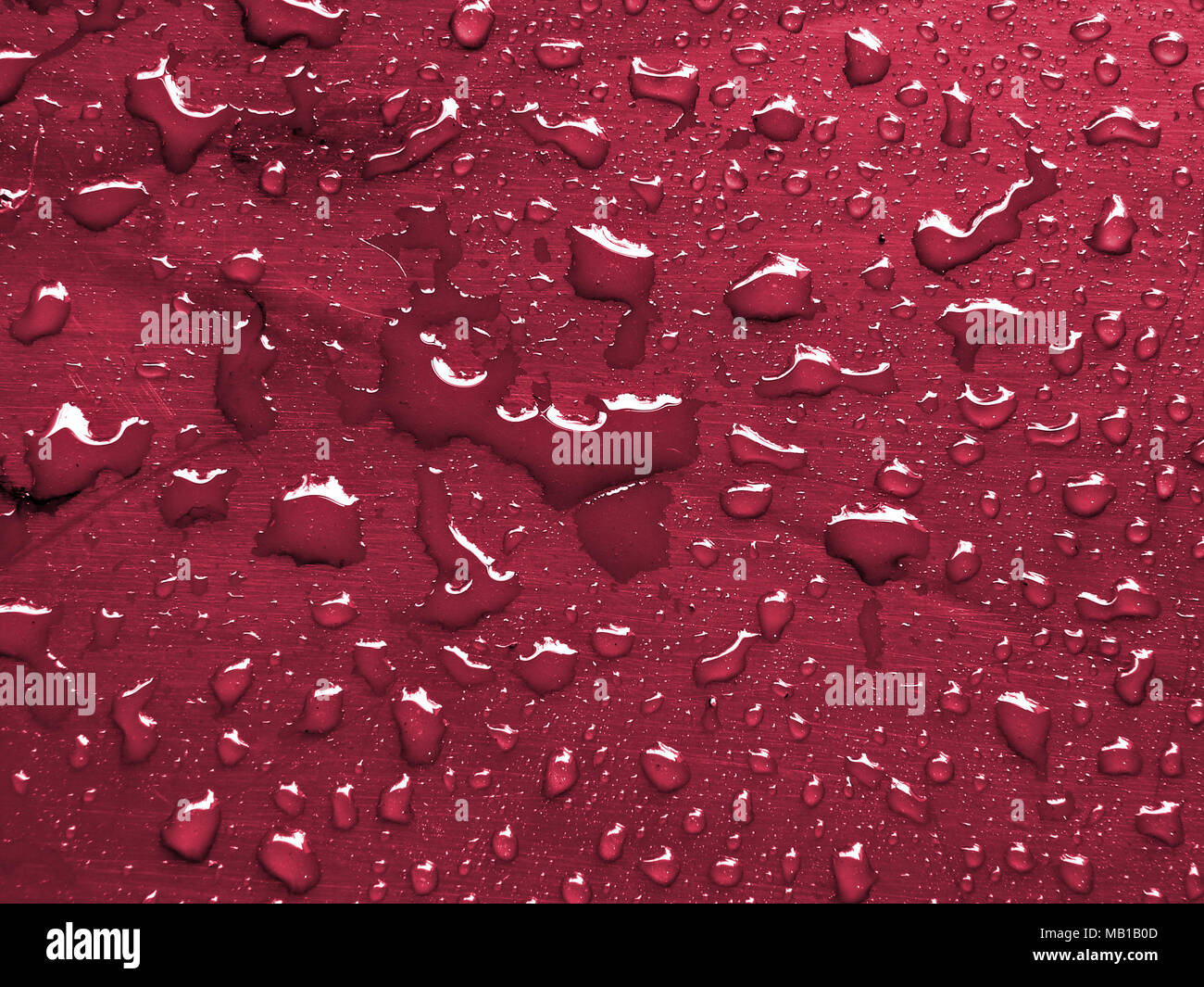 Gocce d'acqua sul vino rosso superficie metallica Foto Stock