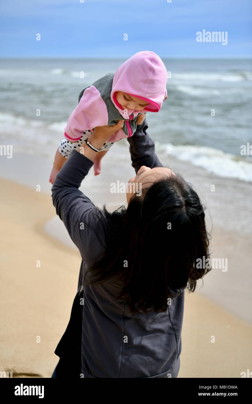 Madre e figlia divertendosi e sorridente sulla spiaggia Foto Stock