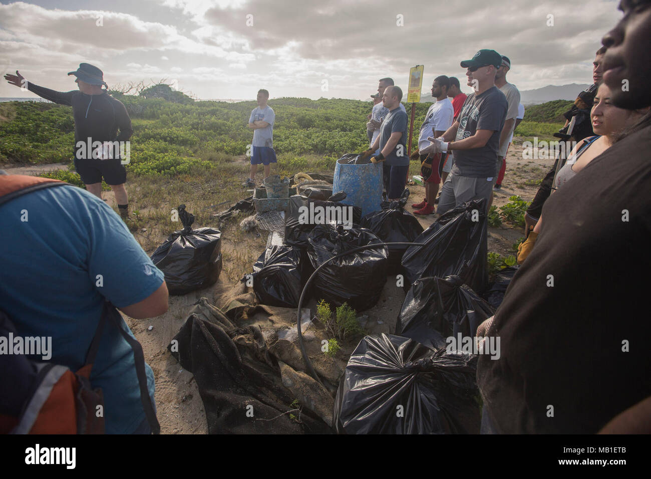 Bookless lancia il senior risorse naturali manager con la conformità ai requisiti ambientali e Dipartimento di protezione, dare una breve ai volontari durante un erbaccia Warriors evento a Fort Hase beach, Marine Corps base Hawaii, il 10 febbraio, 2018. Guerrieri di erbaccia è un opportunità di volontariato per il servizio i membri e il personale di base per facilitare la rimozione delle specie invasive di piante e cestino inquinare l'ambiente. Foto Stock