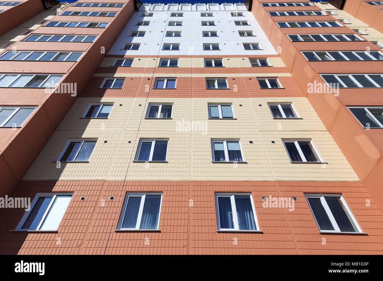 Vista della parte frontale di un edificio con appartamenti da terra con cucina di finestre e balconi che mostra simmetricamente sul lato destro e sinistro Foto Stock