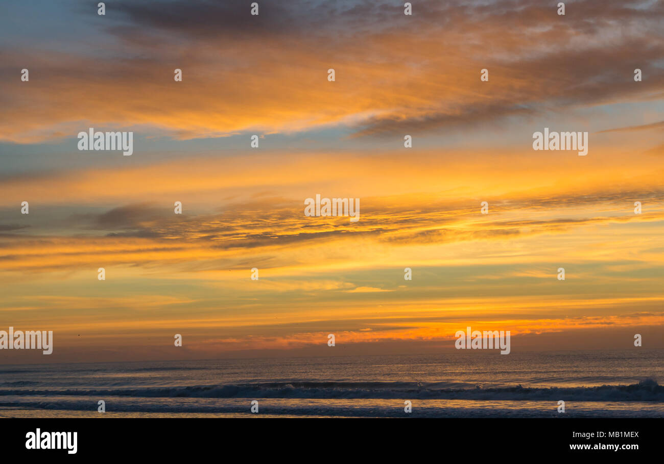 Tramonto con il fuoco nel cielo - Isola di Smeraldo Beach North Carolina. Vedere la bellezza del cielo come le nuvole si raccolgono nel dipinto di rosso, arancione, rosa, incandescente Foto Stock
