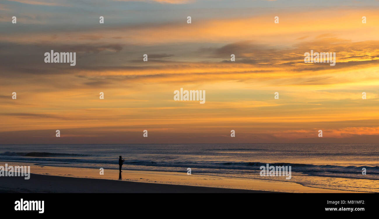 Tramonto con il fuoco nel cielo - Isola di Smeraldo Beach North Carolina. Vedere la bellezza del cielo come le nuvole si raccolgono nel dipinto di rosso, arancione, rosa, incandescente Foto Stock