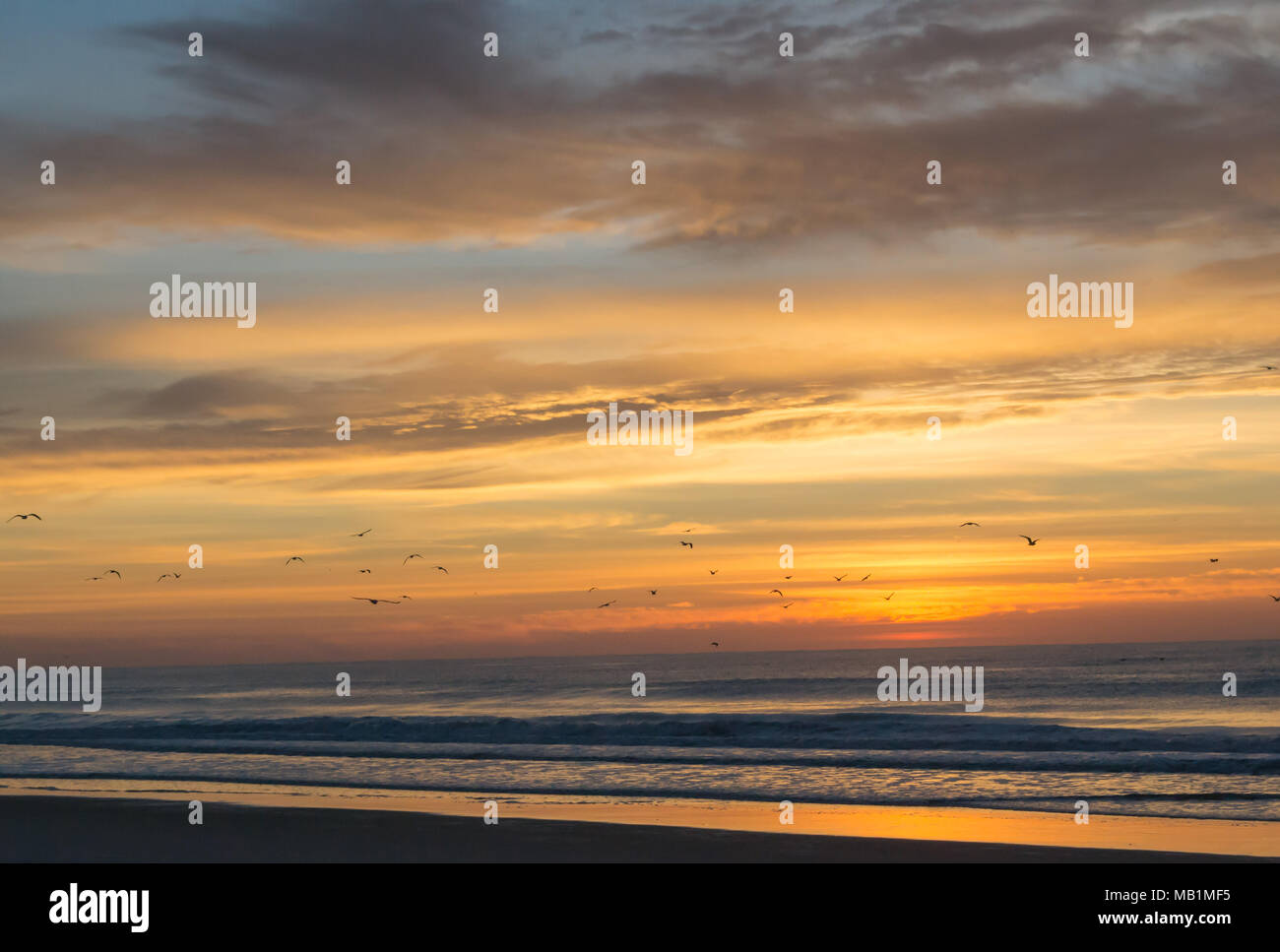 Tramonto con il fuoco nel cielo - Isola di Smeraldo Beach North Carolina. Vedere la bellezza del cielo come le nuvole si raccolgono nel dipinto di rosso, arancione, rosa, incandescente Foto Stock